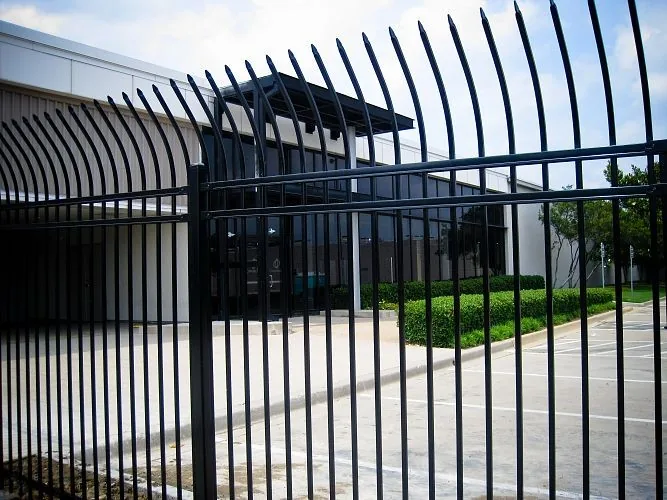 Bent top metal security fence installed beside a commercial building