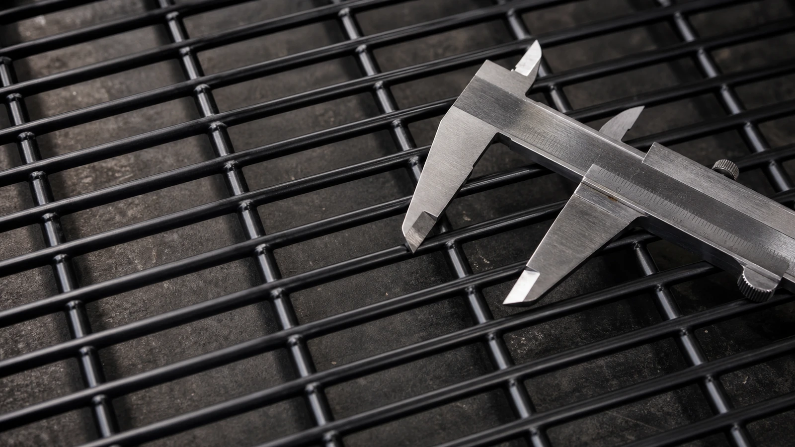close-up of black 358 anti climb welded mesh panel measured with caliper