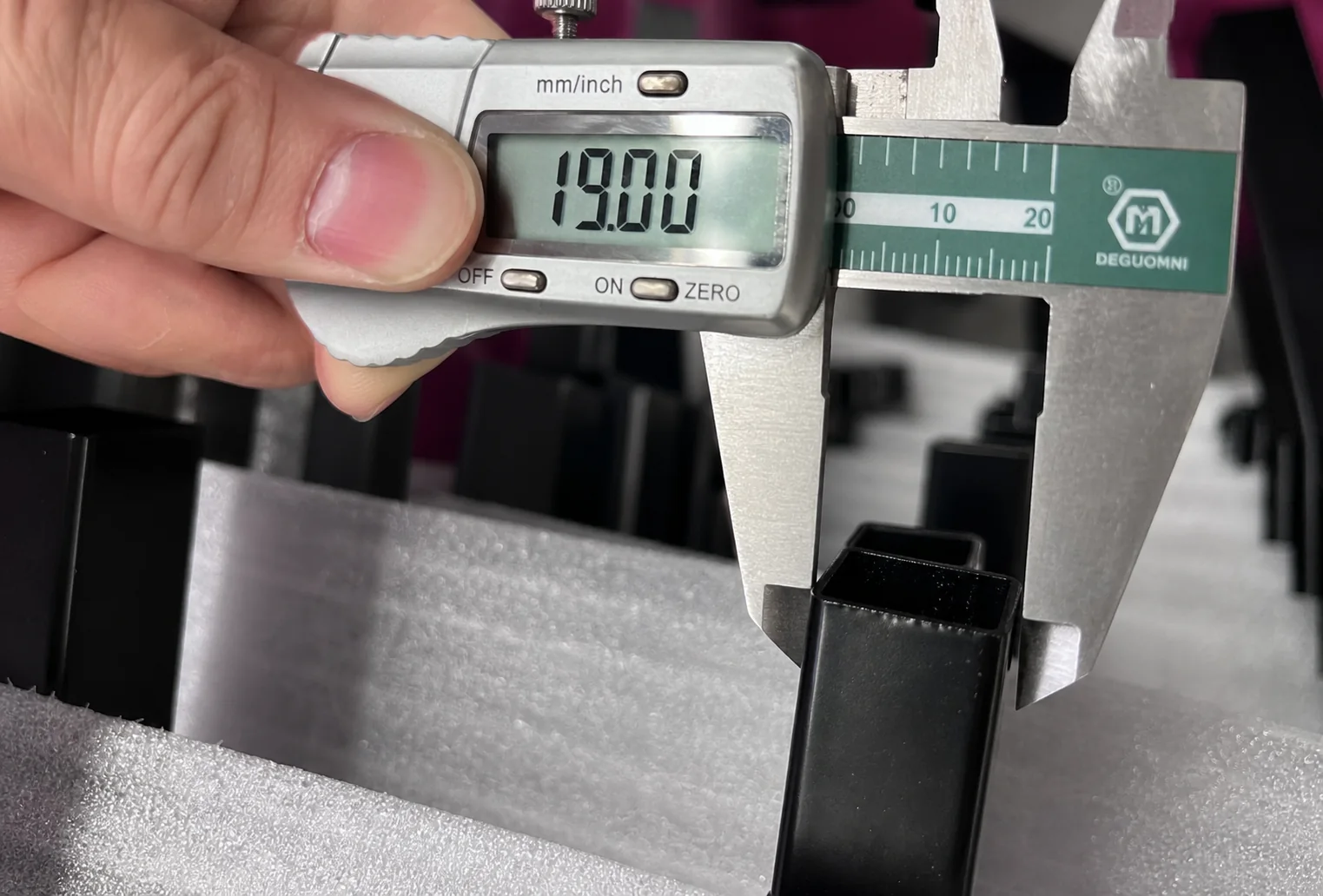 Digital caliper showing 19.00 mm during Pressed Top Steel Fence picket inspection