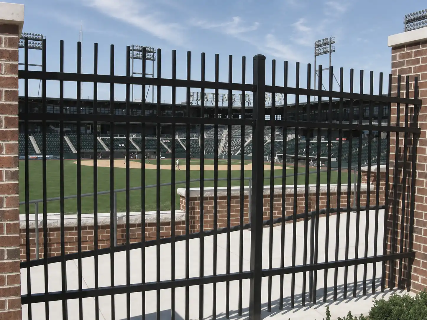 Black steel rod fence panels securing the perimeter of a baseball stadium