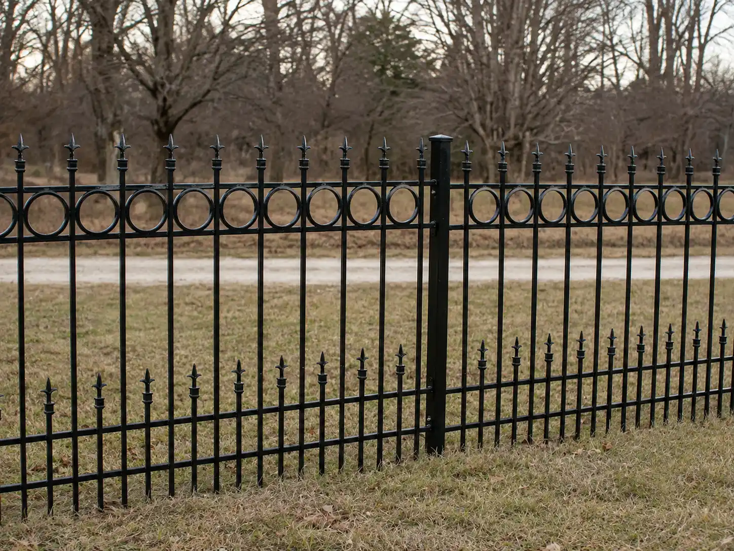 Black steel spear top fence with circular inserts and staggered lower spear pickets